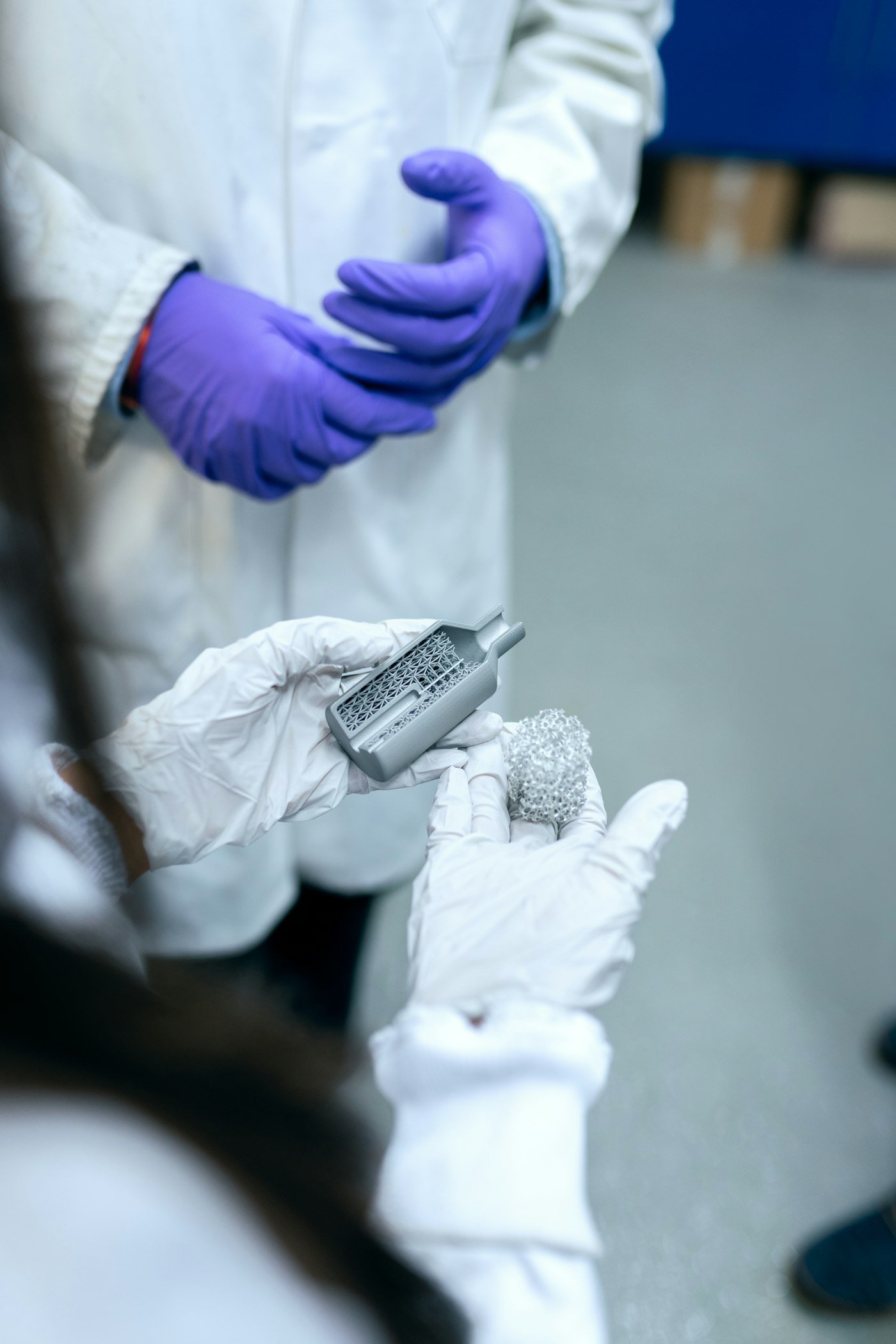 Gloved hands handling a small sample vial in a research laboratory