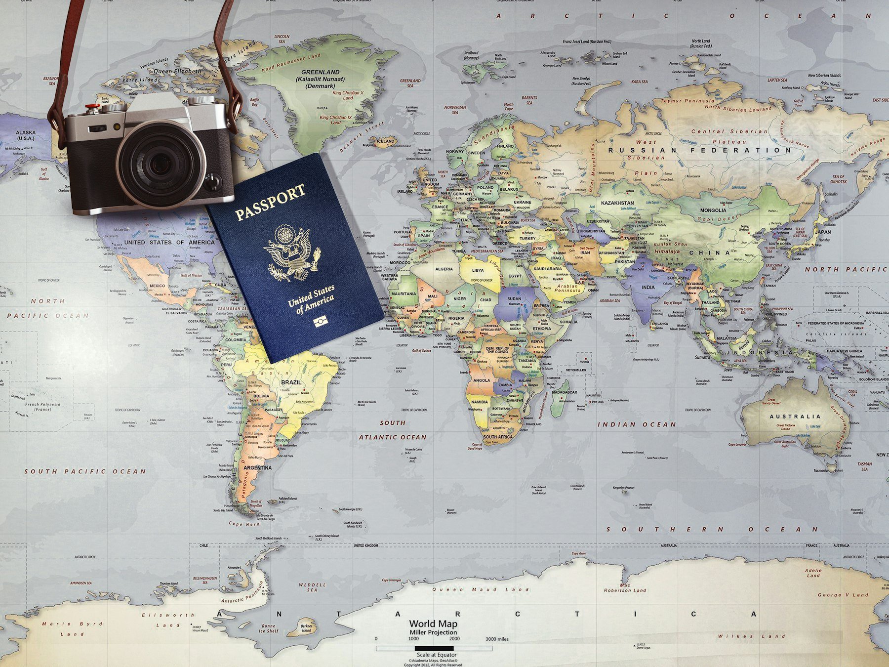 A passport and camera resting on a world map