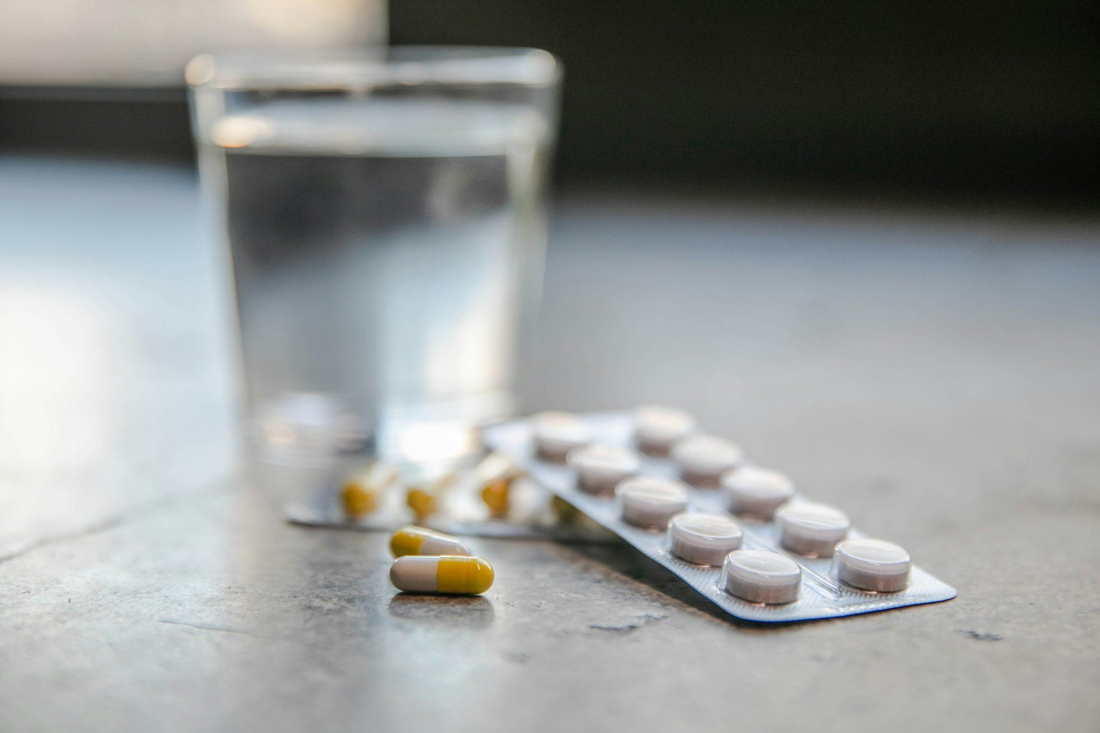 Tablets and a glass of water on a table