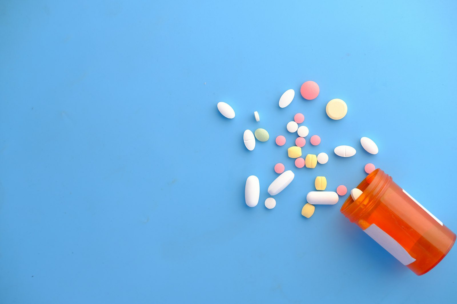 Antibiotic tablets spilling from a prescription bottle