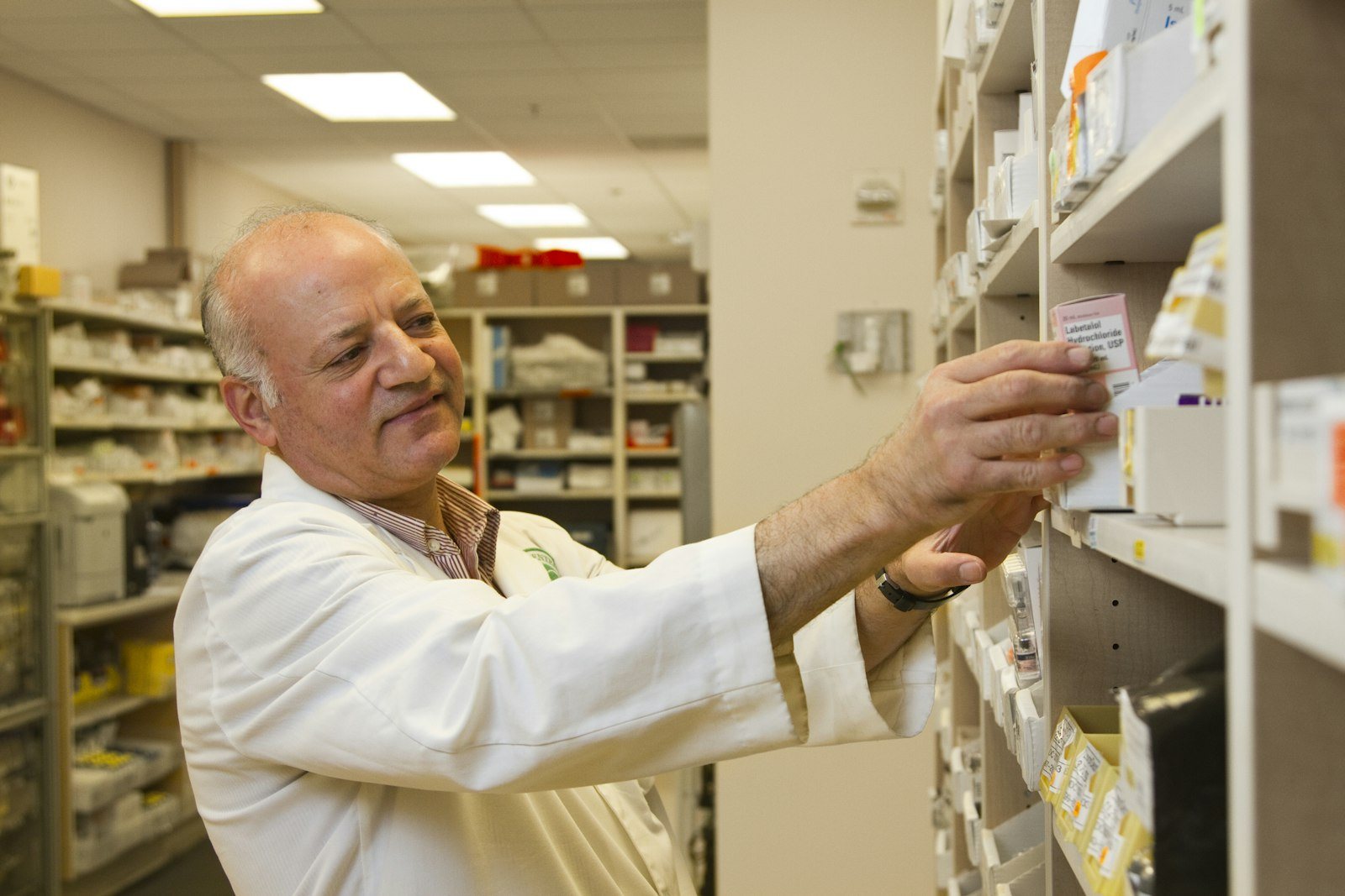 A pharmacy counter with staff assisting