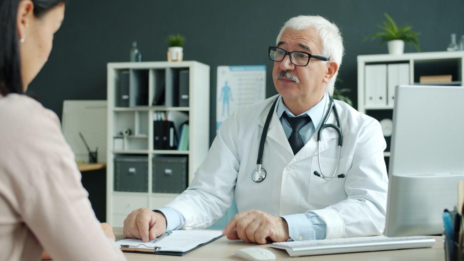 A doctor in consultation with a patient at a clinic desk
