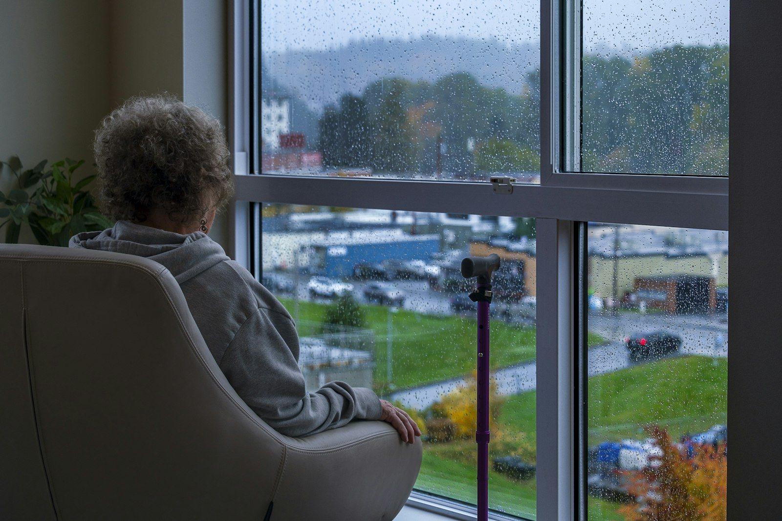 An older person sitting quietly by a window