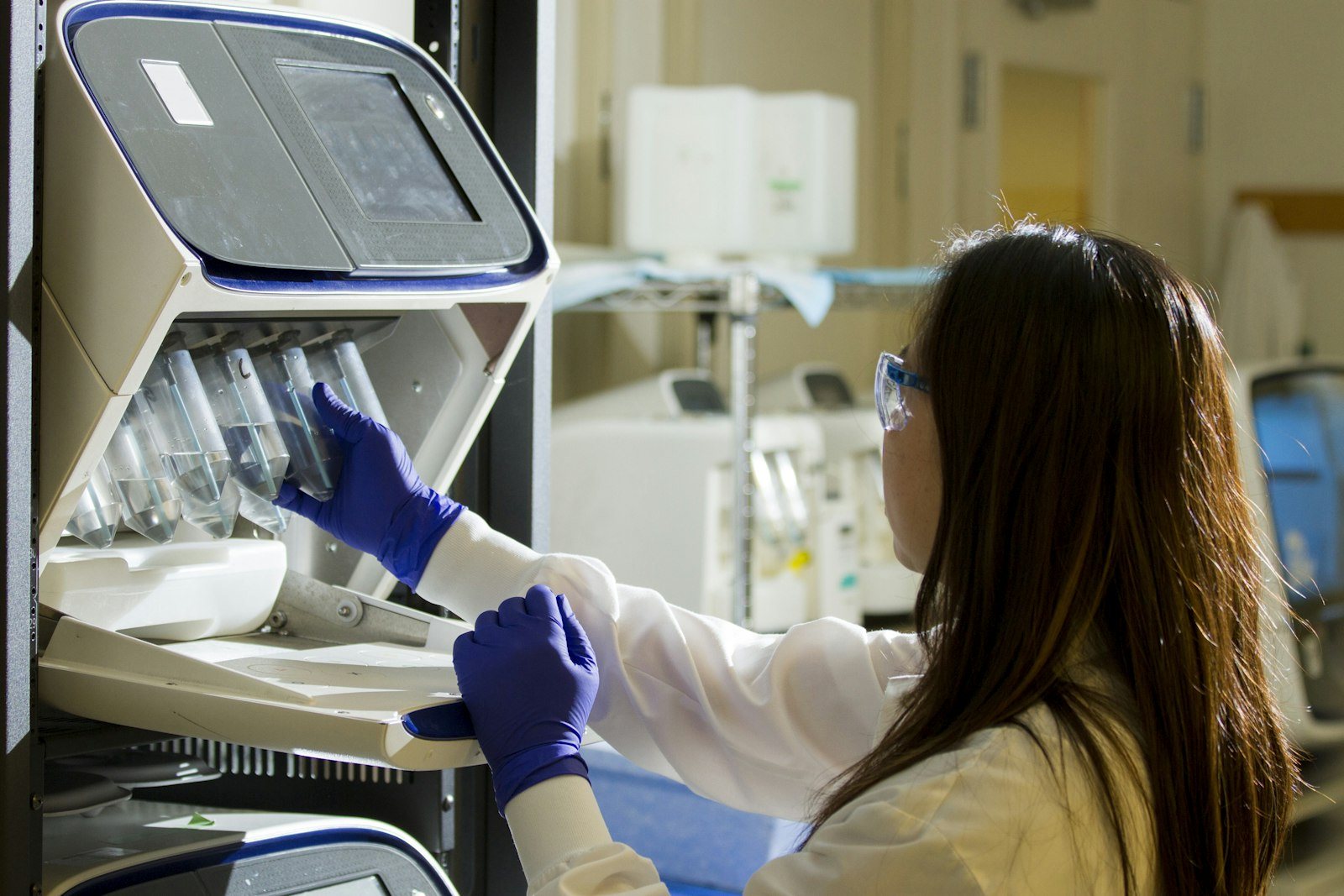 A laboratory technician loading an analyzer