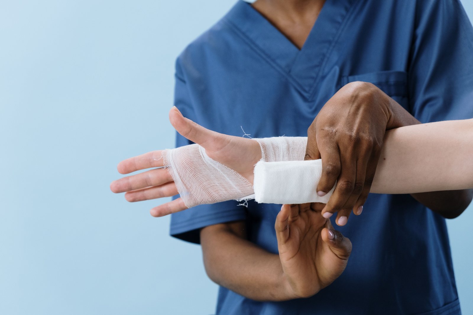 A clinician wrapping a bandage around a patient's hand
