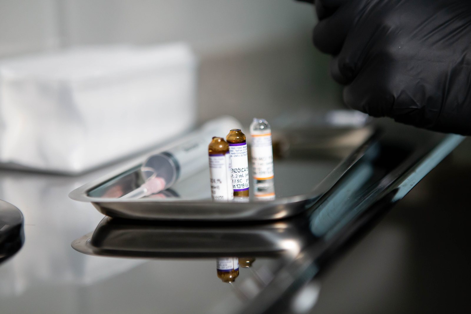 Medical vials and a syringe on a stainless tray